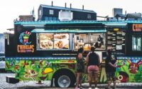 a group of people standing in front of a food truck